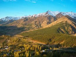 Vista aérea del inicio de la Cordillera de los Andes; en la ladera se ven un pueblo y un nutrido bosque